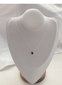 Detail of 925 sterling silver necklace with oval black zircon on a beige mannequin