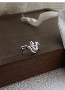 Gros plan sur la bague serpent S925 montrant la texture des écailles et les yeux noirs