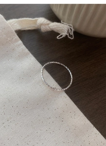 Close-up of S925 sterling silver diamond-cut sparkling ring on a gift bag surface