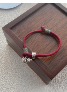 Detail of red braided silk bracelet with S999 silver gourd charm and vintage beads