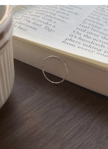 Macro shot of S925 sterling silver diamond-cut sparkling ring on an open book
