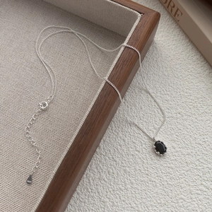 925 sterling silver necklace featuring an oval black zircon pendant on a wooden tray