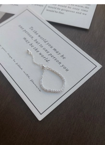Detail of S925 sterling silver chain ring with adjustable bead slider and woven texture