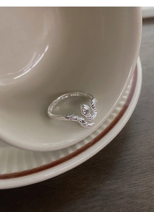 Gros plan sur la bague serpent en argent S925 montrant les écailles et le poinçon