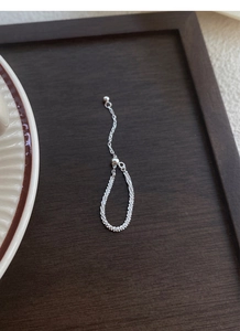 Detail of adjustable S925 sterling silver chain ring with slide bead on wood