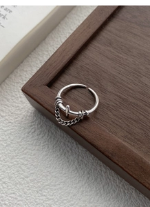 Detail of adjustable S925 sterling silver ring with chain texture on wood tray