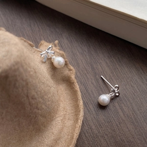S999 silver bow pearl earrings featuring polished metal and elegant white round pearls