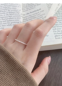 Close-up of minimalist S925 sterling silver pave ring with sparkling zircons on finger