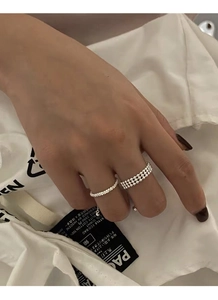 Detail of s925 silver beaded and woven textured rings worn on a hand for minimalist look