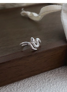 Détail macro de la bague serpent argentée S925 montrant les écailles sur métal poli