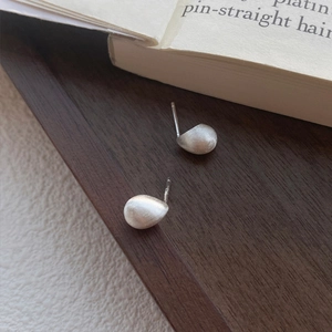 Minimalistische S925 Sterling Silber Bohnenohrstecker mit mattem Finish auf Holztablett