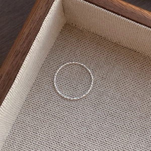 Sparkling S925 sterling silver ring with faceted texture on elegant beige linen display