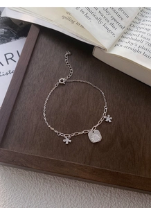 Detailed macro view of S925 sterling silver daisy bracelet with engraved charms and hallmark