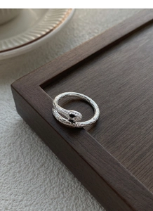 Macro shot of snake ring with silver scale textures and white zircon paved snake head