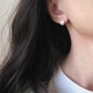 Minimalistische S925 Sterling Silber Tropfen- und Kugelstecker am Ohr eines Models