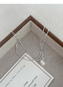 Detailed view of S925 silver double-layer snake chain with freshwater pearl on wooden tray