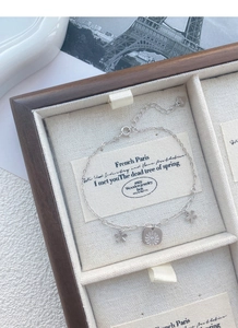 Detail of S925 sterling silver daisy bracelet on a jewelry display box with Eiffel motif