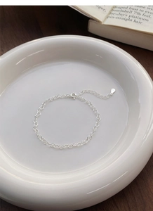 Detail view of S925 sterling silver stamp on minimalist heart link chain bracelet