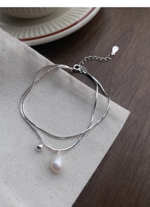 Macro detail of S925 sterling silver stamp on double-layer freshwater pearl bracelet