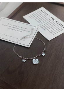 Close-up of S925 sterling silver daisy bracelet with square floral pendant and lobster clasp