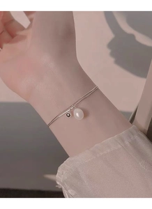 Detail of S925 silver double layer bracelet with pearl drop on female wrist