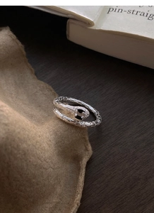 Macro shot of silver snake ring featuring black gemstone eyes and scaled texture details