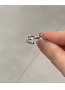Detailed shot of S925 silver open bow ring with minimalist hollow design and bead tips