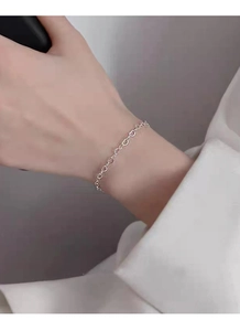 Detail of S925 sterling silver chain bracelet with delicate heart-shaped links on wrist