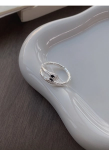 Macro shot of silver snake ring featuring detailed scales and black gemstone eyes