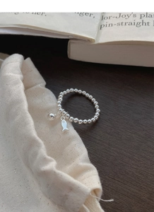 Détail de la bague en perles d'argent S925 avec pendentifs de poisson et de cloche