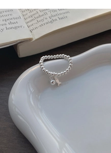 Détail de la bague en argent S925 avec perles et breloques de petit poisson et boule