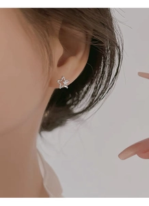 Macro detail of a sparkling S999 silver star stud earring with inlaid cubic zirconia