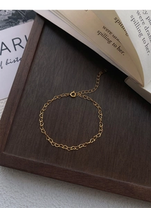 Close-up of golden S925 sterling silver heart chain bracelet with engraved metal hallmark