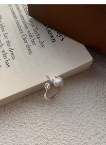 Detail of S925 silver matte gourd ring with zircon inlay set on a book page