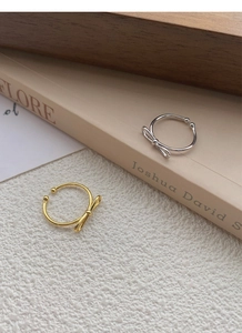 Detail of gold and silver bow-knot rings on vintage books with soft warm lighting