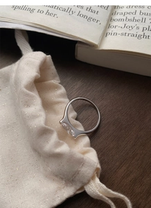 Close-up of S925 silver marquise-cut ring placed on a textured gift jewelry pouch