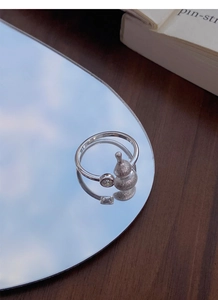 Macro detail of silver frosted gourd ring with zircon on a reflective mirror base