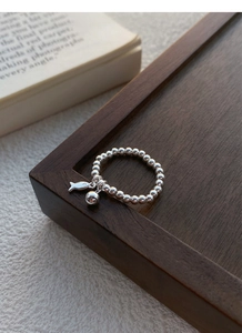 Détail de la bague en perles d'argent 925 avec pendentif poisson et boule polie brillante