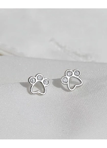 Makroaufnahme von Silber-Katzenpfotenohrringen mit weißen Zirkonia auf Seidenhintergrund