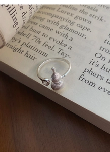 Detailed view of S925 silver gourd ring with matte finish and zircon on a book