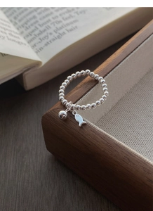 Détail de la bague en perles d'argent S925 avec breloques de petit poisson et bille