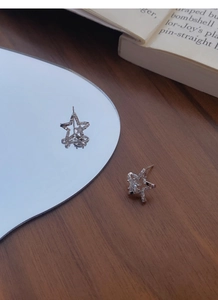 Detailed macro view of S999 sterling silver star stud earrings with zircon inlay