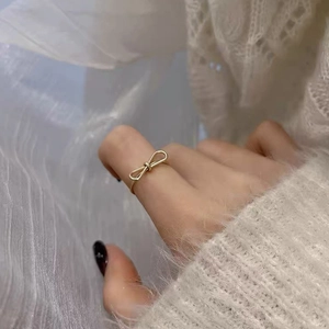 Minimalist S925 sterling silver hollow bow open ring in gold finish on female model