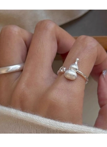 Detail of frosted gourd silver ring with zircon on hand over a cozy white sweater