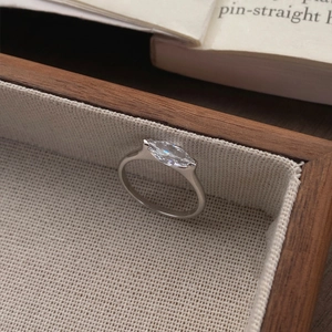 S925 sterling silver marquise cut diamond ring on a rustic wooden tray with burlap