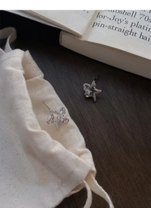 Close-up of S999 silver star stud earrings with sparkling zircon on an open book