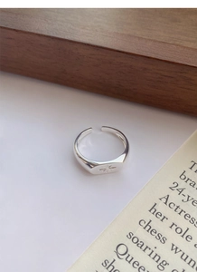 Detail of S925 sterling silver starburst signet ring with polished adjustable band