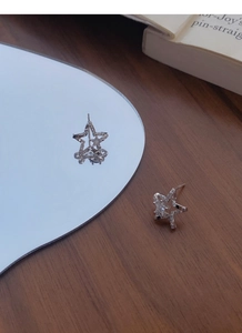 Macro view of S999 sterling silver star stud earrings with sparkling cubic zirconia