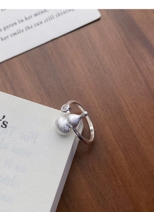 Macro detail of S925 sterling silver frosted gourd ring with zircon on book pages