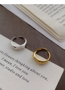 Detail of gold and silver signet rings featuring an engraved eight-pointed star design